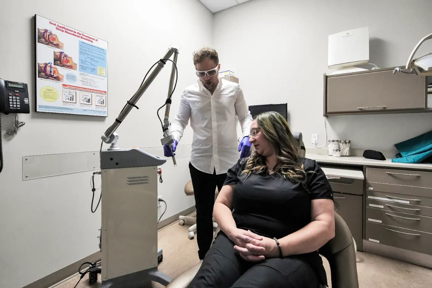 Dr. Sepehr Jafarpour performing DEKA CO₂ laser therapy on a seated patient