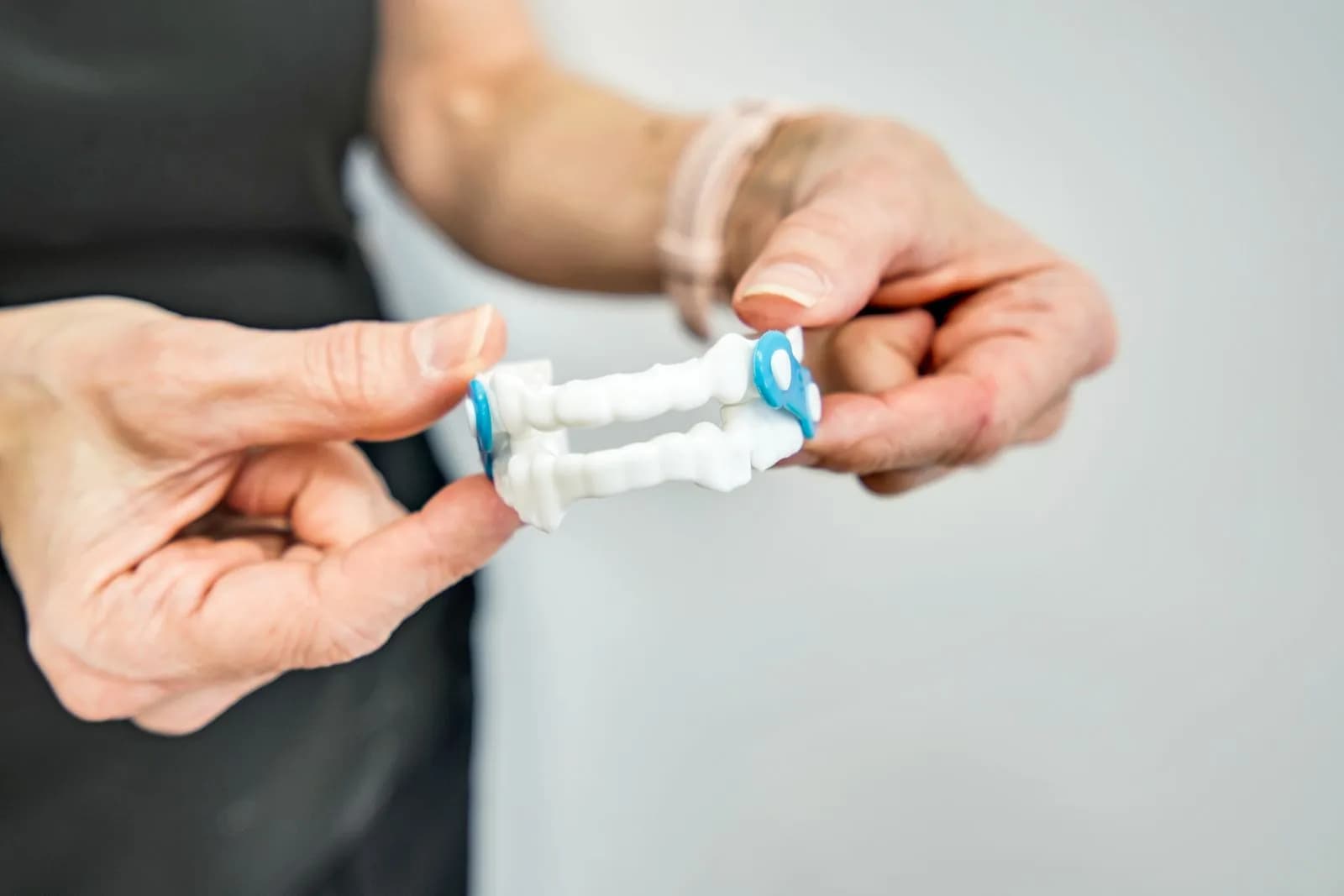 A dental team member holding a custom oral sleep appliance