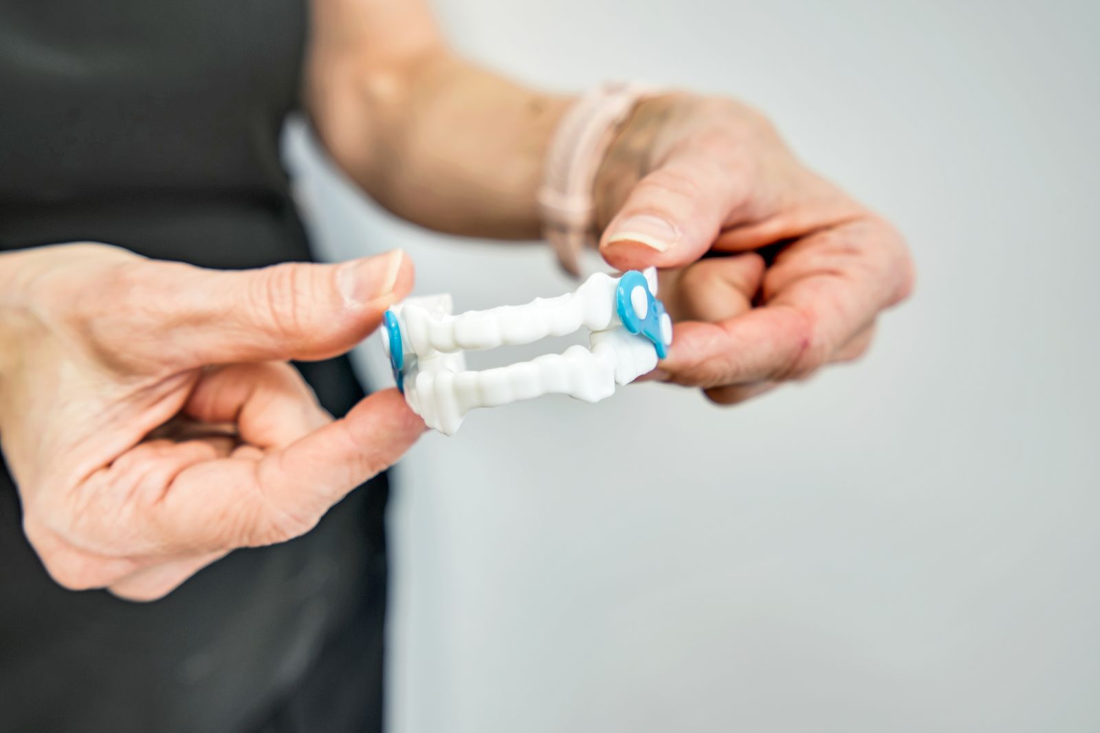 A dental team member holding a custom oral sleep appliance